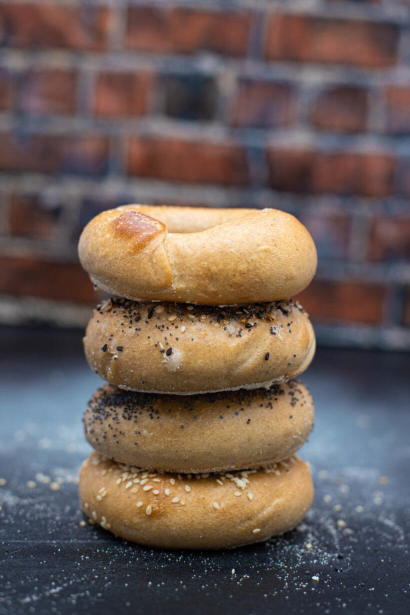 stack of sourdough bagels, plain, everything bagel seasoning, poppy seed and sesame seed made with the recipe on this page