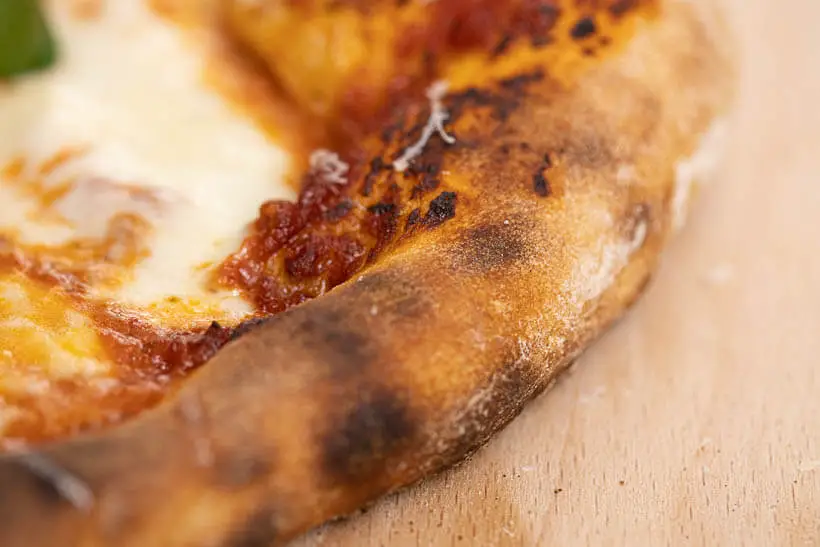 skorpen på en perfekt pizza margarita med surdej. lær at lave den i denne opskrift