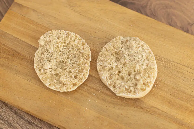 Fork-split English muffins on a wooden board