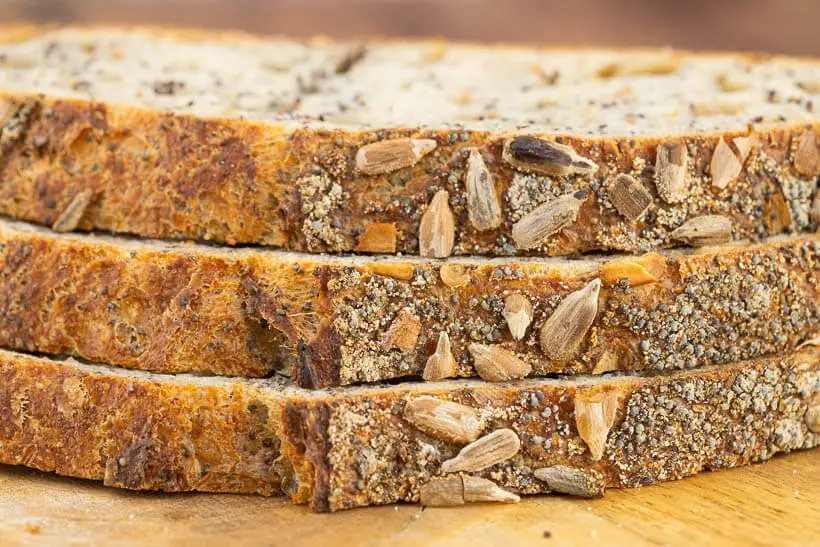 Three slices of sourdough bread with poppy seeds and sunflower seeds on the crust and in the crumb