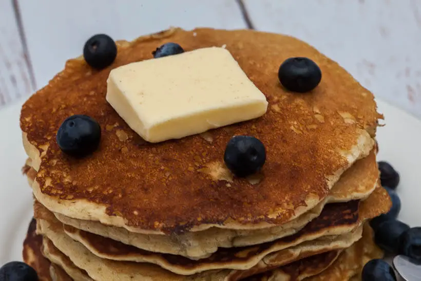 Closeup of a stack of pancakes with blueberries and butter on top