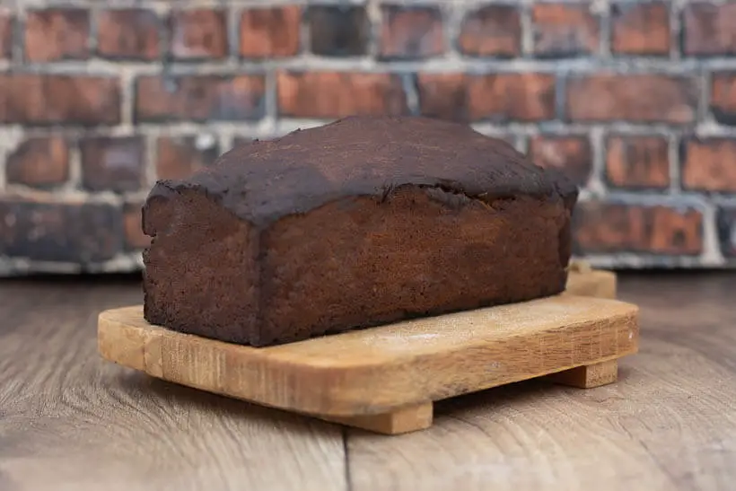 Limpa Bread on a wooden board in front of a brick wall