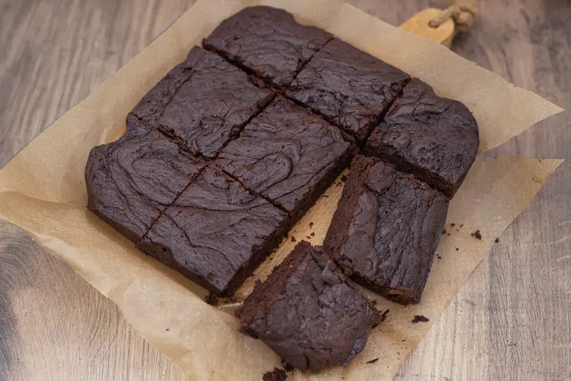 fudgy brownies on a piece of parchement paper