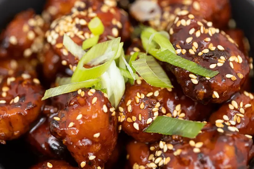 closeup of korean fried chicken with  toasted sesame seeds and a sticky glaze made with this recipe