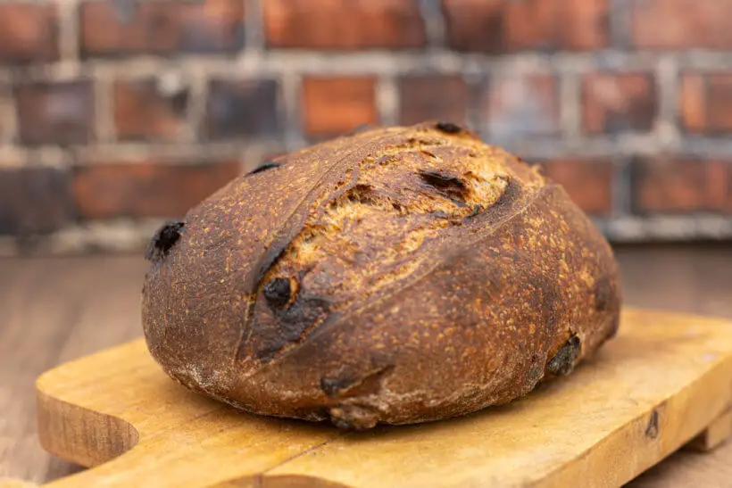 a sourdough walnut cranberry bread on a wooden board