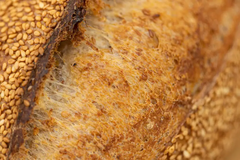 close up of the oven spring and sesame on this sesame sourdough bread