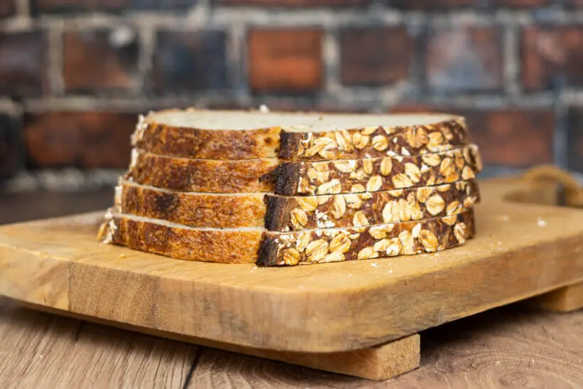 slices of honey oat sourdough bread on a board
