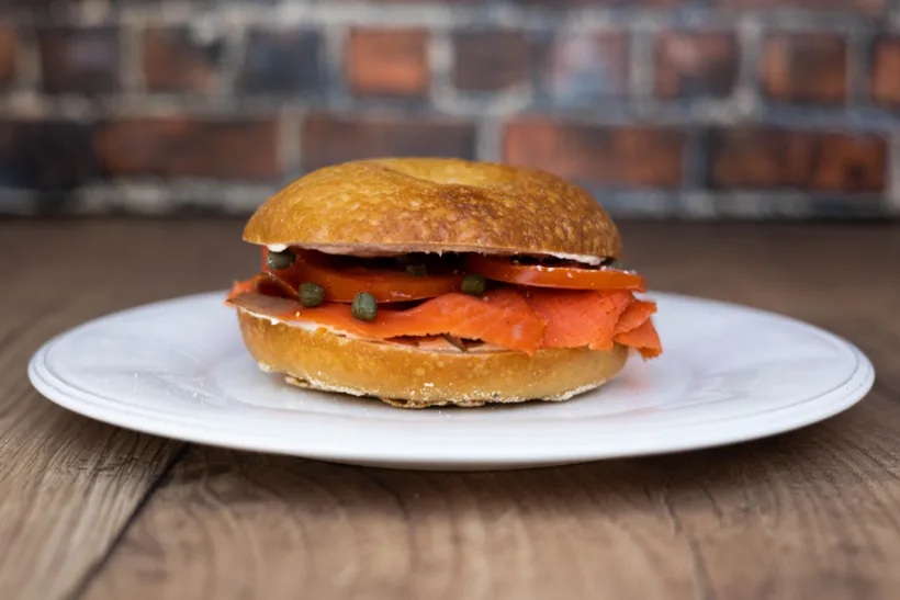 a classic new york bagel with lox, cream cheese, tomato, and full-fat cream chese.
