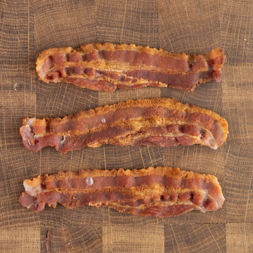 Thin strips of bacon cooked in a cast iron skillet