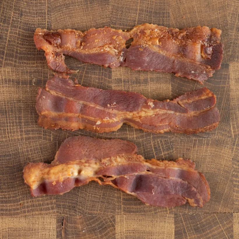 Thick strips of bacon baked in the oven with parchment paper