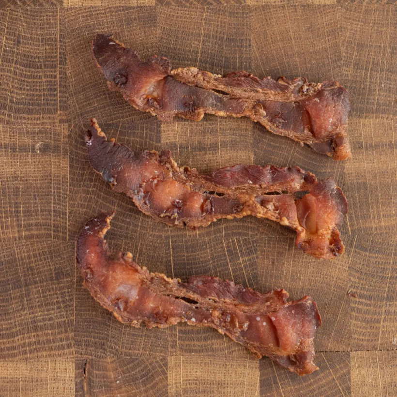Thin strips of bacon baked in the oven on a rack