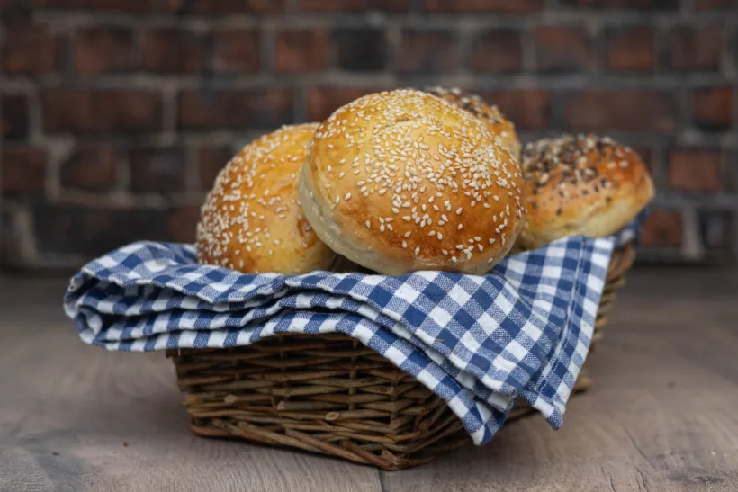 potato buns in a basket lined with kitchen towel